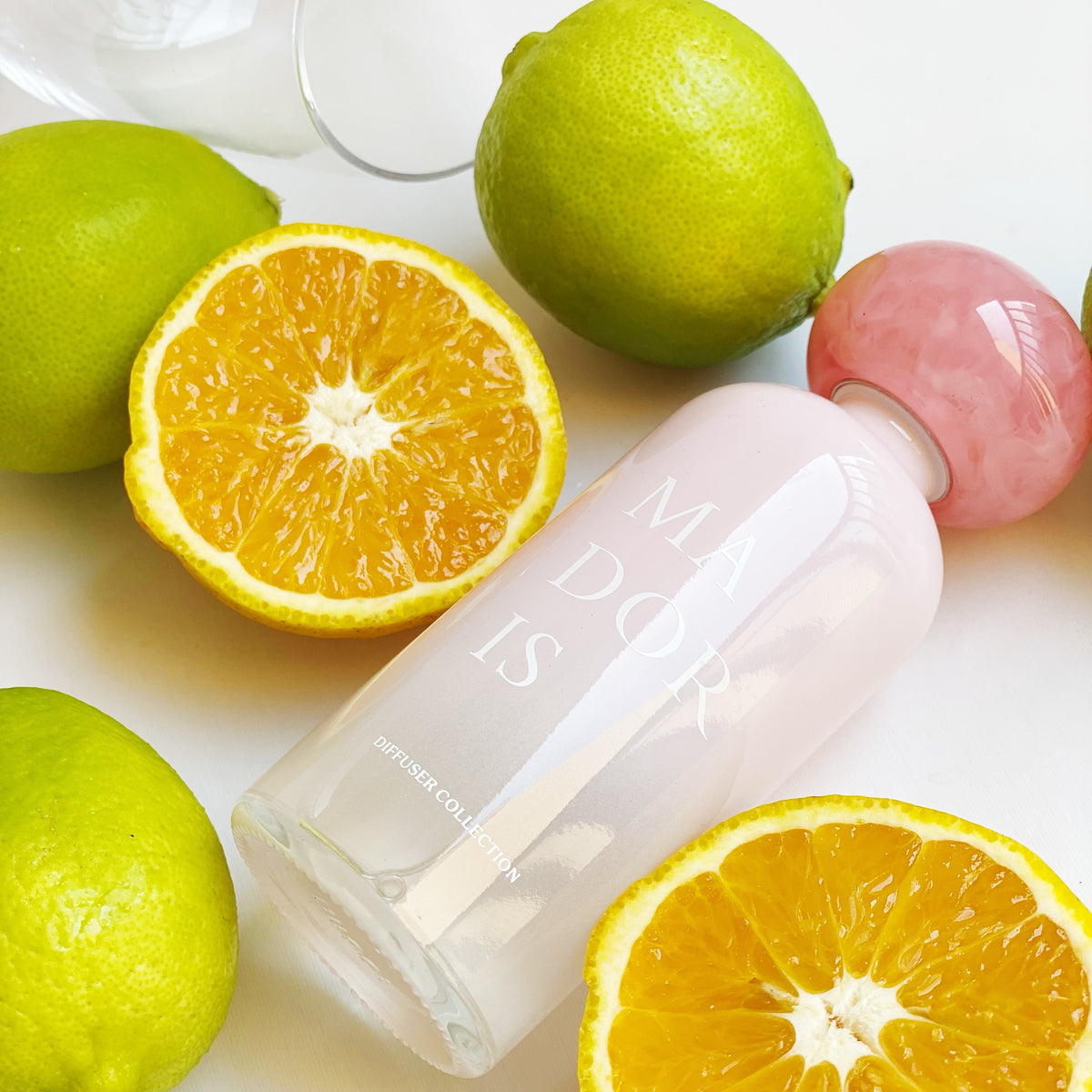 MADORIS Blush Veil reed diffuser styled with fresh citrus fruits in a bright minimal setting
