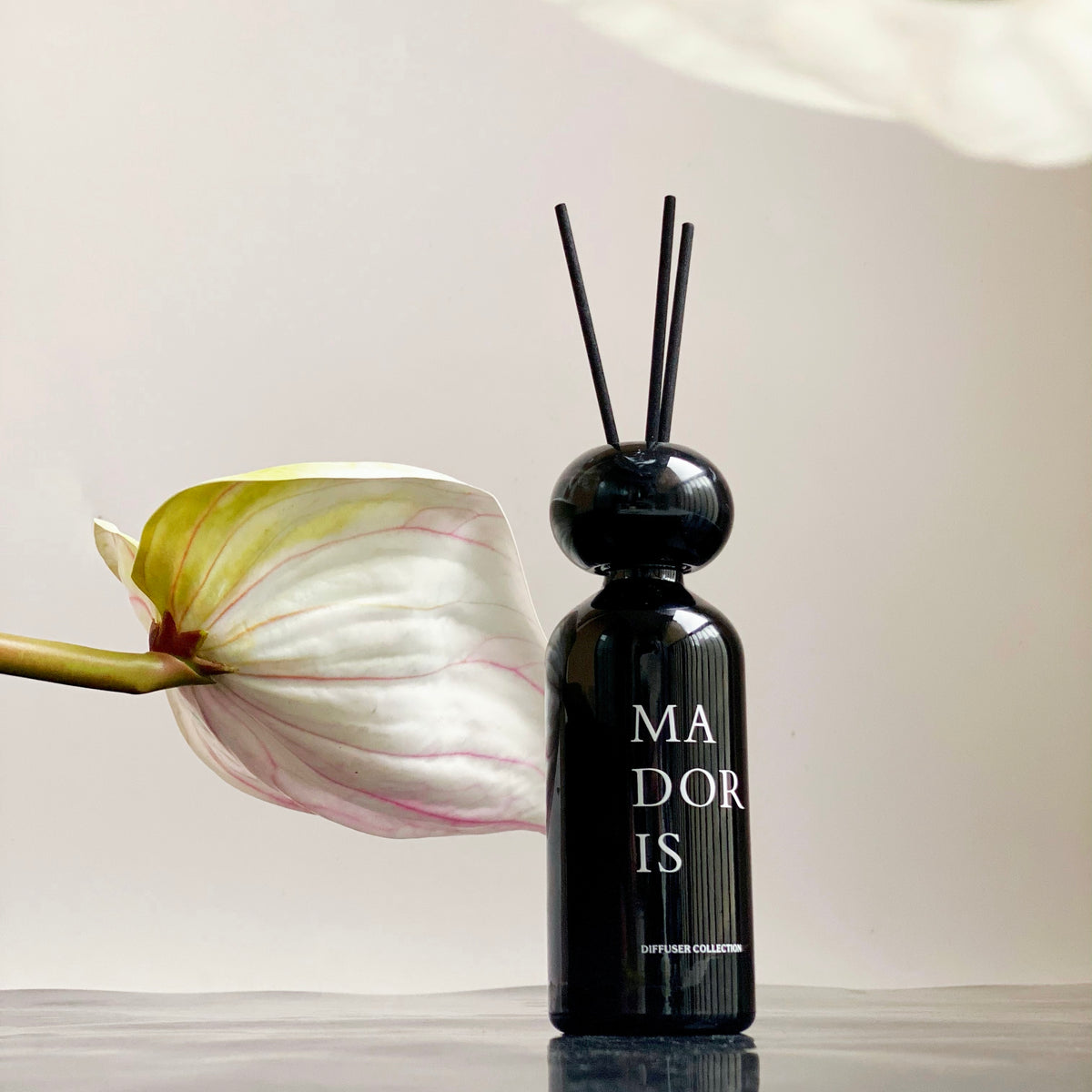 MADORIS Dark Citrus reed diffuser displayed in a minimal interior with soft natural light