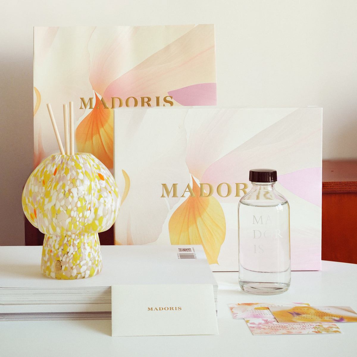 MADORIS Golden Hour reed diffuser arranged in a refined still life with MADORIS fragrance objects