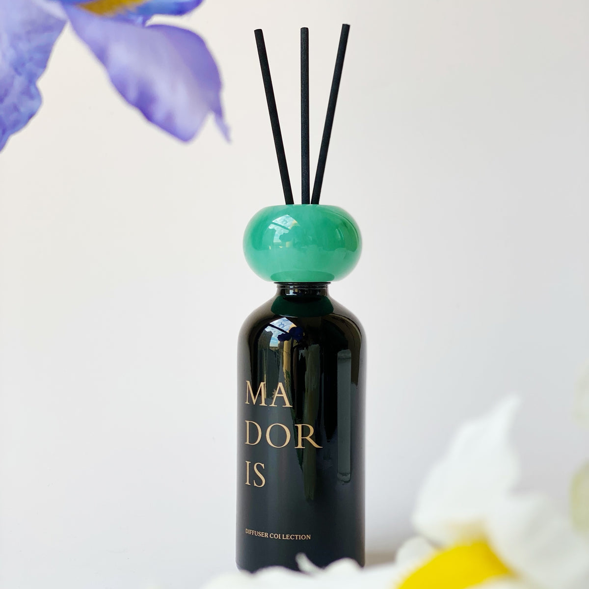MADORIS Jade Mist reed diffuser displayed with black reeds and soft floral details