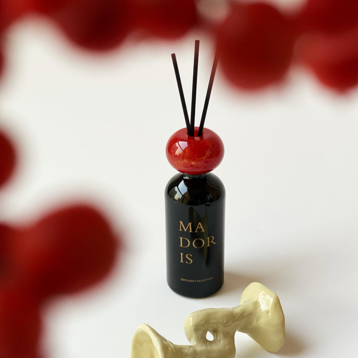 MADORIS Midnight Kiss reed diffuser with black reeds in an elegant interior setting