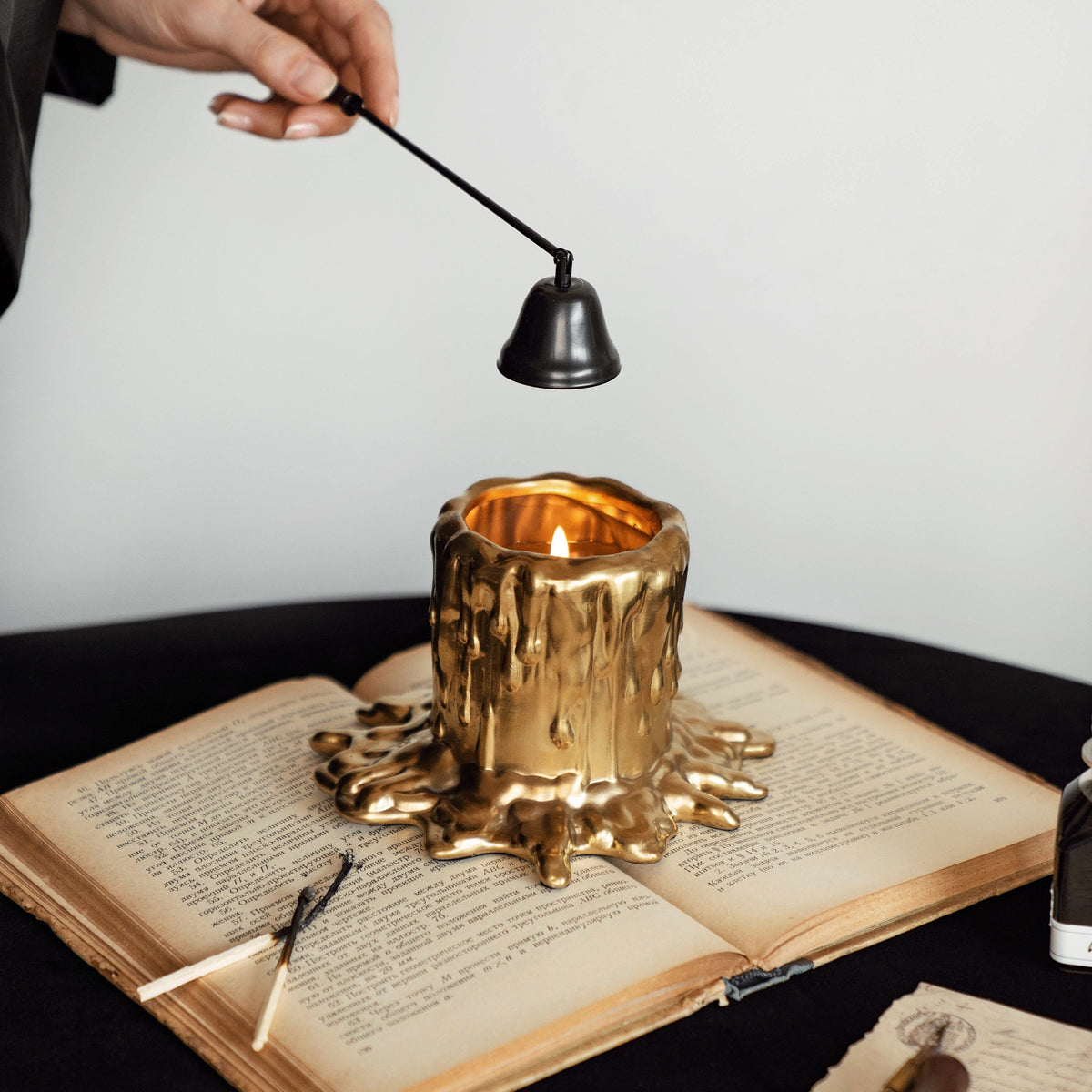 MADORIS Molten Bloom scented candle in use with molten gold wax detail